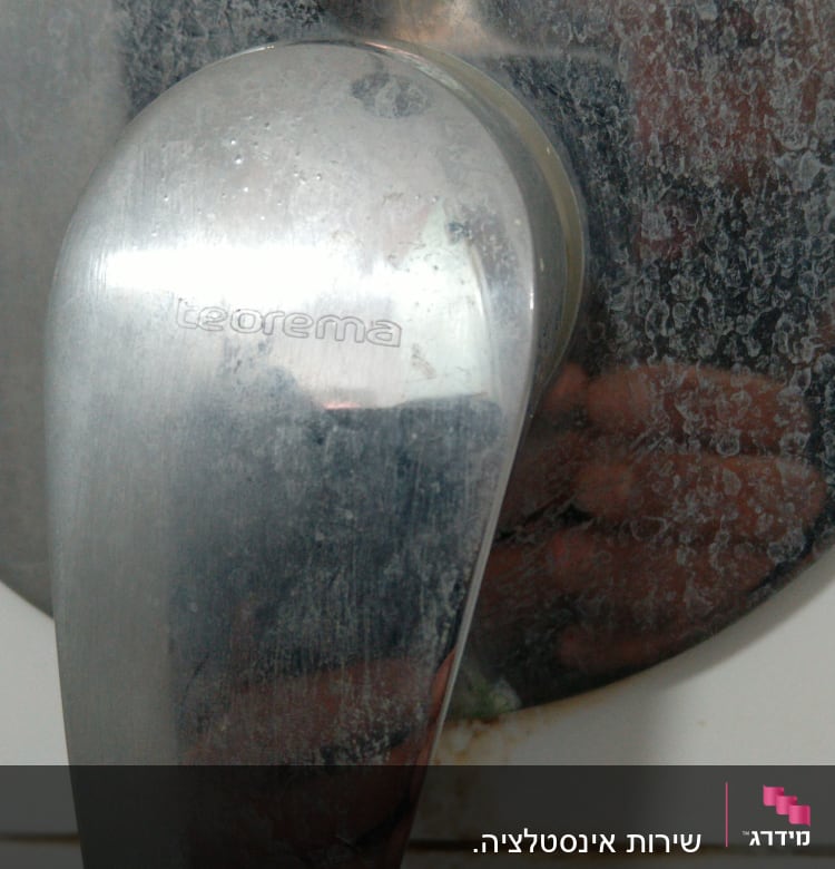 ידית ברז מתכתית עם כתמי אבנית